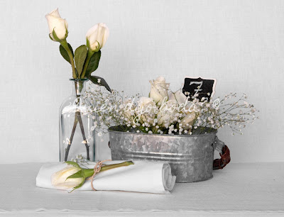 Decoración para mesas de la recepción con rosas blancas y paniculata y número de mesa en pizarra