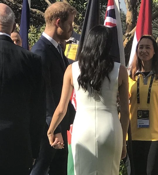 Meghan Markle wore a white Blessed dress by Australian designer Karen Gee, and she wore ​Stuart Weitzman suede pump in Haze Beige