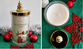 a white candle in a glass jar with a beautiful gold lid with a christmas tree on.