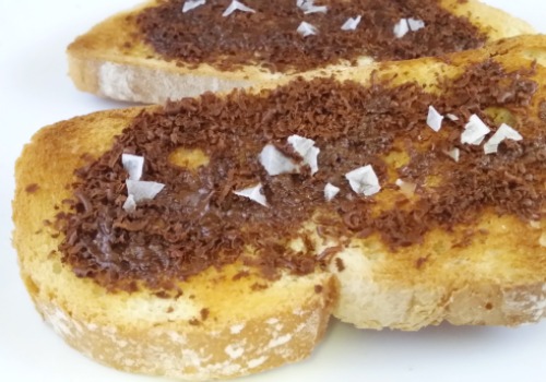 Dos tostadas con chocolate, aceite y sal