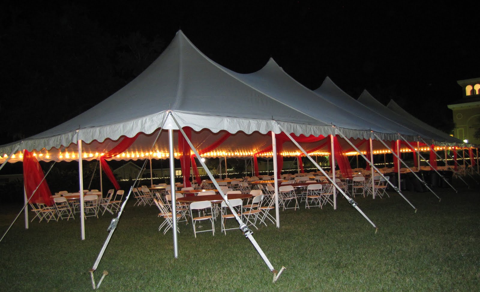 Party People Event Decorating Company Tent Organza Swags at night time.