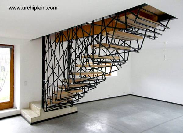 El soporte de los escalones de madera es una jaula de metal intrincada - Arquitectura www.archiplein.com Escalera interior de metal y madera muy original en Francia