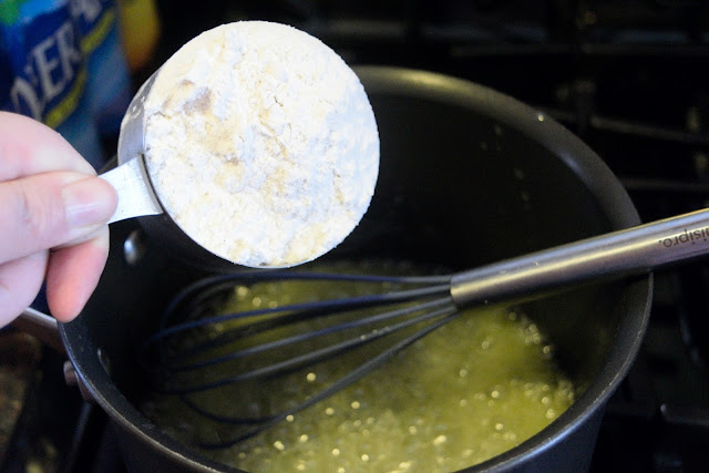 Flour being added to the melted butter, in the sauce pan.