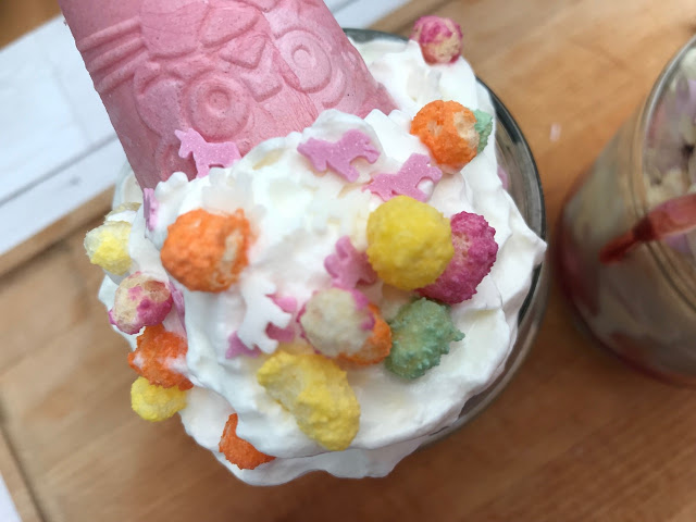 Unicorn sprinkles,rainbow drops and a pink cone added to the cream