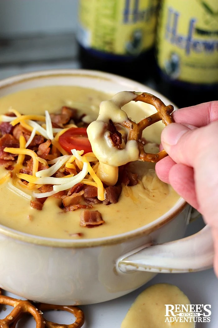 Beer cheese Dip with bacon on pretzel ready to take a bite! 