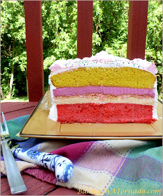 Lemon Raspberry Ice Cream Cake, two flavored cake layers, two ice cream layers and a crunchy center and frosted with whipped cream. A delicious summer treat. | Recipe developed by www.BakingInATornado.com | #recipe #dessert #cake