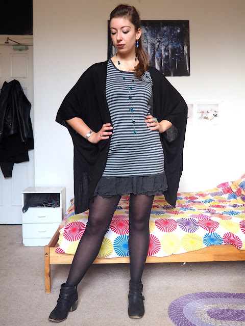 Hades inspired Disneybound villain outfit of grey striped knit dress, black cape cardigan, black ankle boots & blue stone jewellery