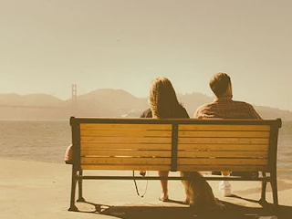 couple on bench in front of hills