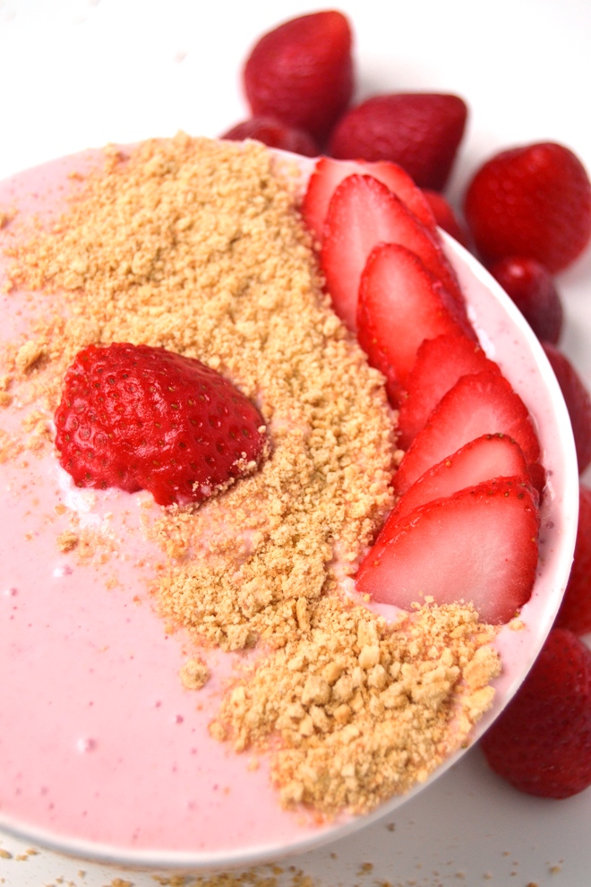 Strawberry Cheesecake Smoothie Bowl is a 5-minute nutritious treat that tastes like your favorite cheesecake and is topped with sliced strawberries and graham crumbs! www.nutritionistreviews.com