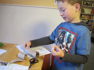 Dash making a cardboard telescope.