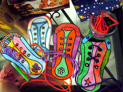 Resultado del proceso de creación de zapatos de cartón: siluetas coloreadas, algunas ya con cordones ensartados. Fotografía ©Selene Garrido Guil