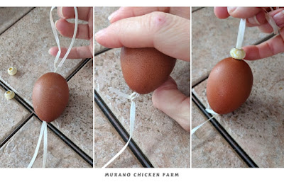 Hanging a blown egg by a ribbon.