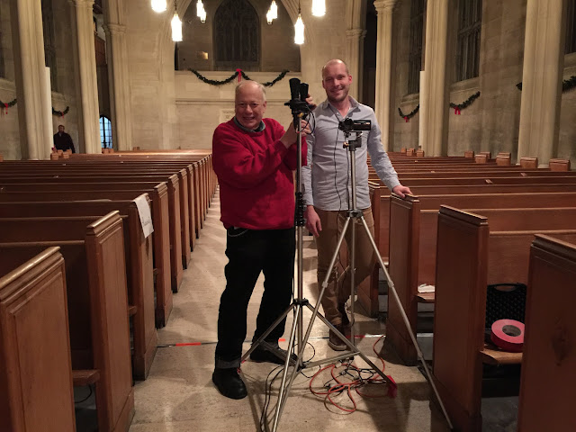 Tom Barnes sets up his professional mics with camera volunteer