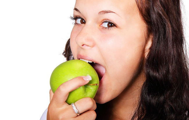 Donna che addenta una mela