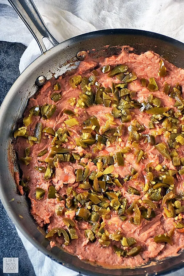 Refried beans spread to cover skillet and topped with diced jalapenos