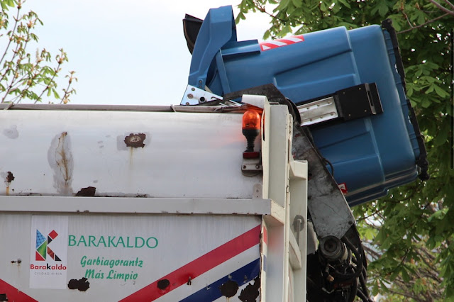 Un camión recoge la basura de un contenedor
