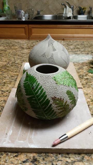Ceramic pottery vessel with leaf imprints, this time fern fronds, in progress.