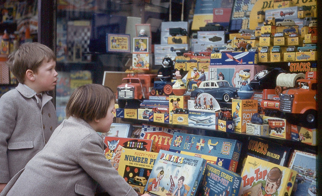 Children stare at toys of a toy shop in Henley, UK, 1960 vintage everyday