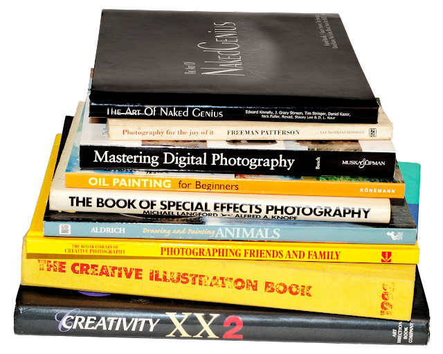 A series of hard cover art and photography books stacked.