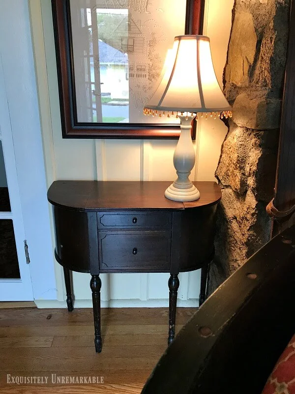 Small Vintage Sewing Table next to a stone fireplace
