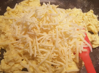 Cheese in pan on top of scrambled eggs