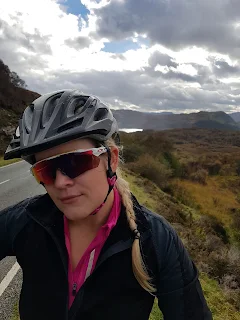 moody highland sky woman in oakley sunglasses with road bike