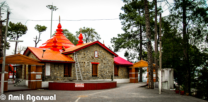 Sankat Mochan Temple is one of the popular Temples in Shimla Town. It's not exactly in Shimla, but quite near to it. Let's have a quick Photo Journey from Sankat Mochan Temple by Amit Agarwal.. Sankat Mochan Temple is actually located near to Tara-Devi which comes on the way to Kalka from Shimla Town. It's approximately 10 kilometers from Shimla Town. Place is surrounded by green mountains all around. Temple is adjacent to the National Highway - 22. The temple is a place where one can actually meditate and enjoy the calm and peaceful surroundings.The very first photograph above shows a temple on left, which is located just after main entry into the Sankat Mochan Temple. This temple is created in South Indian Style.Around 1950, a Baba came to this beautiful place and discovered the perfect spot for meditation and soulful introspection. After staying here for 10 days, he desired that a temple dedicated to Lord Hanuman should be built here. Baba's faithful devotees included the governor of Himachal Pradesh, who along with Bhagvan Sahai took up the task of building the temple and fulfilling their Guru's wish.Sankat Mochan temple has many facilities for people and also includes a three-storey building that is used for many purposes. Every Sunday, the huge hall in the building is used for distributing Prasad, also known as Langar. Langar at Sankat Mochan is quite different and very well managed.  One portion of the building is used to conduct marriage ceremonies and is rented out to people who want to conduct marriages. The temple charges a very nominal fee for this. Apart from marriages, there are many other sacred rituals and ceremonies that can be conducted over here. Priests and the maintenance staff, who work here day and night, use the rest of the building as a residential complex. The temple also has an Ayurvedic clinic...Here is a photograph showing interiors of main Sankat Mochan Temple.There are few small Temples in the campus which are dedicated to different godsSankat Mochan Temple is dedicated mainly to Lord Hanuman, though one finds idols of Lord Rama, Shiva and Ganesha in separate complexes. There is a specially made temple for Baba Neeb Karori Ji Maharaj also. The temple dedicated to Lord Ganesha has been built in the South Indian style of architecture and is worth the visitSankat Mochan Temple is popular temple in Shimla region, which attracts people from all ages and genders who come here to pay obeisance to Lord Hanuman. Sankat Mochan Temple is second most famous temple after Jakhu Temple dedicated to Lord Hanuman. This temple located 5 km away from a beautiful hill station ShimlaOne can have easy transportation to Sankat Mochan Temple from Shimla Bus Stand and other places. From Shimla there are frequent buses till Taradevi and have a stoppage near Sankat Mochan Temple. If you there on Sunday, don't miss the Langar. Langar at Sankat Mochan is quite different and lovableAbove photograph shows the view of Shimla Town from Sankat Mochan Temple.