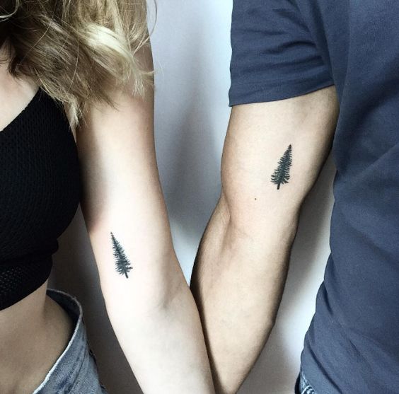 Vemos un tatuaje en pareja de árbol en el interior del brazo