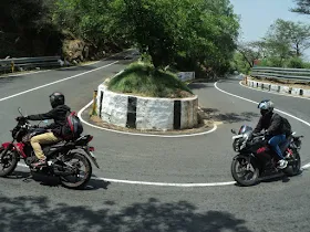 Four bikes parked on the scenic Yelagiri hillside road