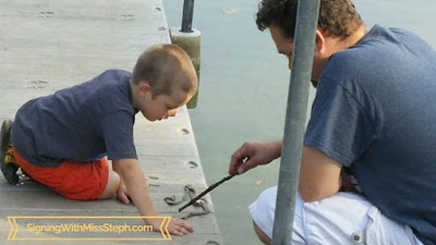 looking at a snake skin on the dock next to the pond