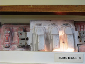 Moulds for sandcasting toy cars on display.