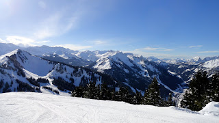 Sunny blue Sky views of the wintery French Alps during the ski season from on top of the mountains. 