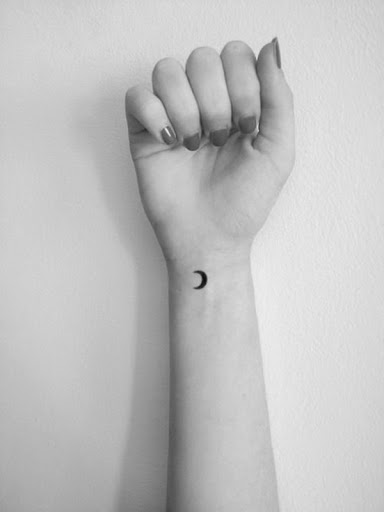 Uma pequena preto lua crescente é representada na portador de pulso simples tatuagem.