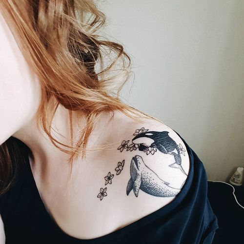 tatuaje de orca y ballena en el ombro de una mujer