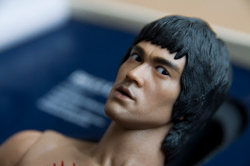 Boneco de Bruce Lee olhando meio torto para a câmera
