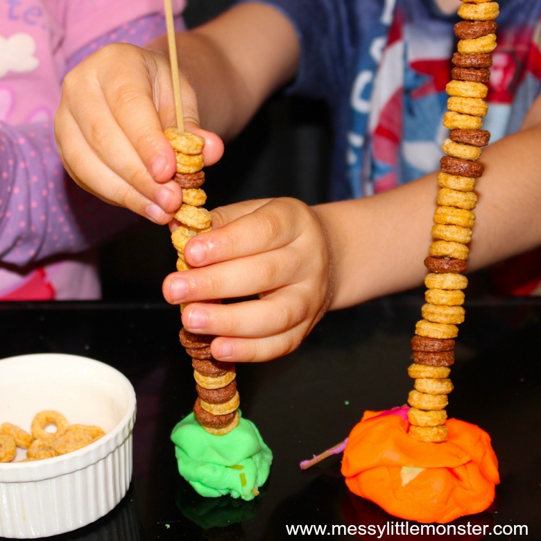 Fine motor pasta threading activity for kids. An easy and fun tower building challenge that works on fine motor skills.  Great for toddlers and preschoolers working on hand eye coordination and strengthening fingers ready for writing. Using just dried spaghetti, cheerios and playdough this challenge can be set up in minutes. 