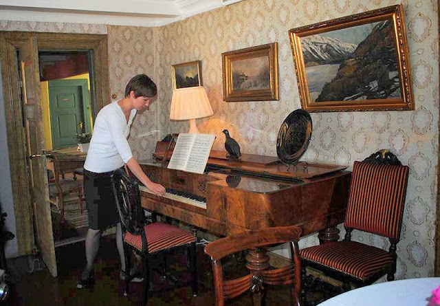 Look very carefully at the flairs above the piano, one in front of Bente and the other to the right of the glow of the lamp. Could this be Mother Utne? Photo: Denise Dubé.