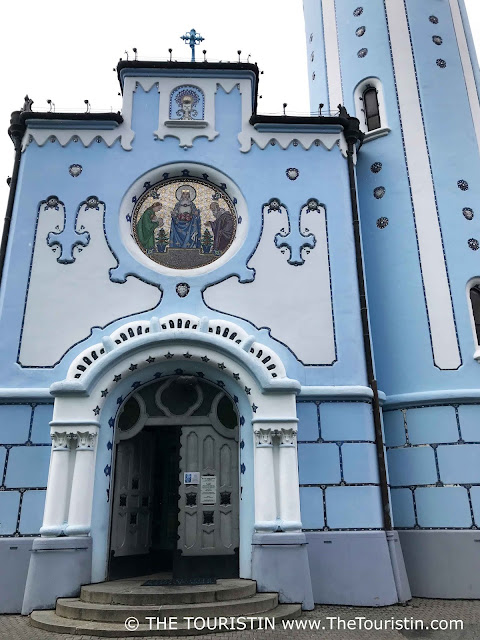 Blue and white painted art nouveau facade and entrance door decorated with stars, of a  catholic church