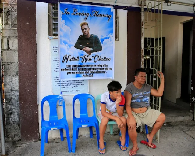 Image Attribute: Relatives sits in-front of a poster of Neptali Celestino, who was killed in a police anti-drugs operation, at his wake in Pasig city, metro Manila, Philippines September 15, 2016. Picture taken September 15, 2016. REUTERS/Romeo Ranoco