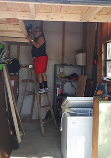 Putting up a shelf in the golf cart shed.