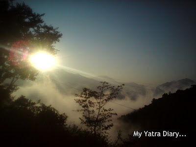 Sun peeping out from behind the cloud cover just before sunset in the Garhwal Himalayas
