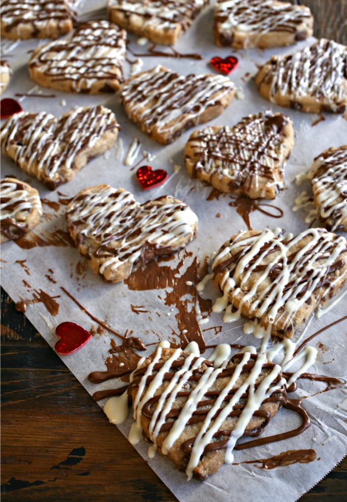 Recipe for heart shaped shortbread cookies filled with semi-sweet chocolate chips and drizzled with milk and white chocolate.