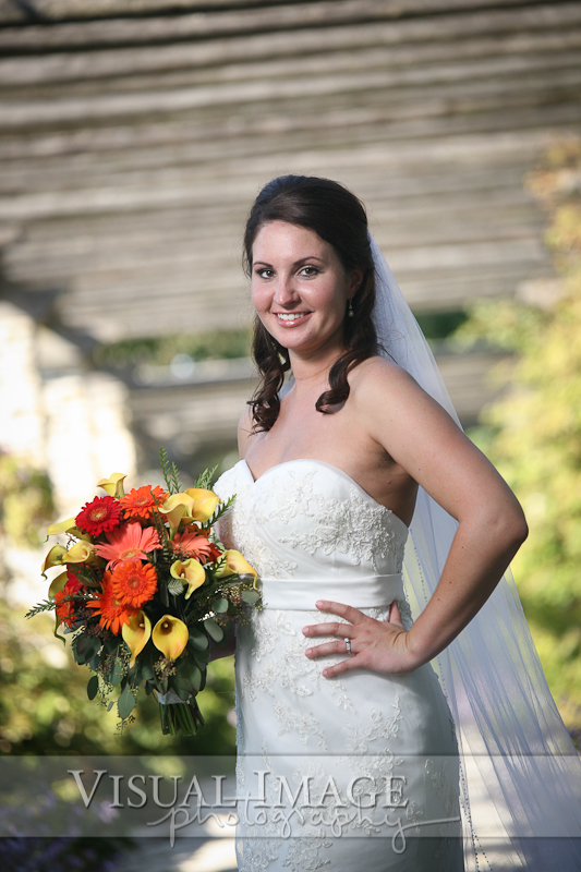 Portrait of bride with bouquet underneath arbor in Frame Park