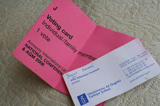 Amnesty International business card and AGM voting card.