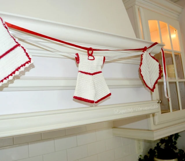 Red and white crochet potholder banner on hood