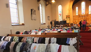 Pews at St Paul's festooned with clothes. Toys, furniture and bric-a-brac was across the front