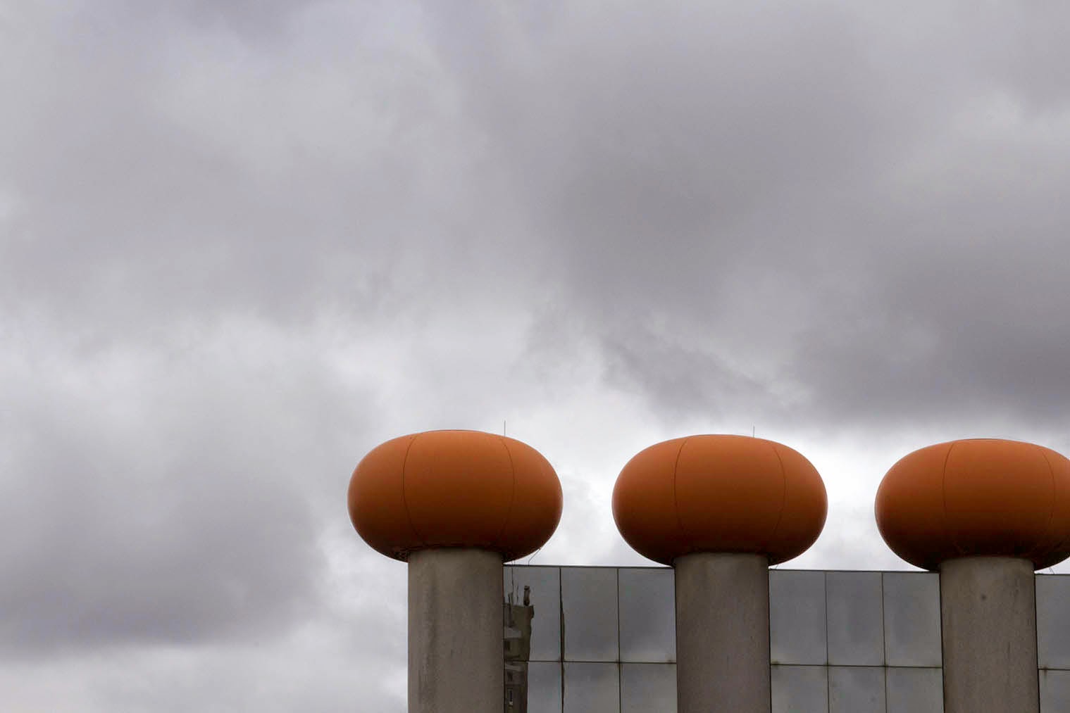 three orange balls and a grey sky
