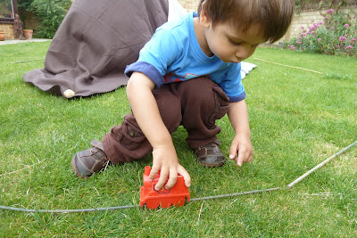 Child playing with sticks and trains
