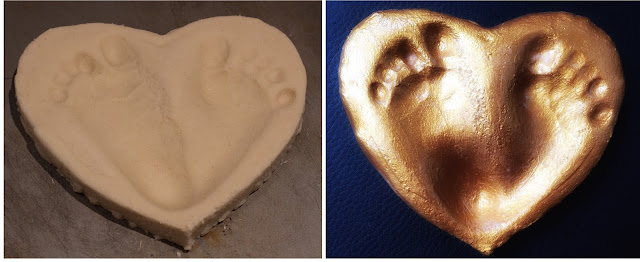 Unbaked salt dough heart with baby footprints and painted with metallic paint