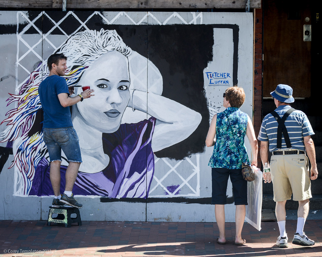 An artist fletcher curran per the name visible in the photo working on a painting in congress square the canvas for the piece is a temporary wooden